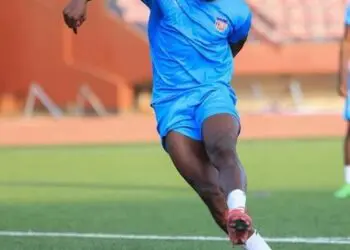 Edward Ledlum trains with the Liberian national team ahead of international fixture, wearing blue kit and preparing to strike the ball.