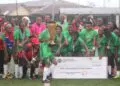 Shaita Angels FC celebrate with trophy and symbolic $1,000 check after winning the inaugural Caresyburg International Cup in 2024.