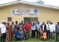 Officials and community members pose in front of the Liberia Land Authority County Office in Gbarnga following the successful resolution of a decades-old land dispute with LACRA.
