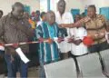 Local officials and healthcare workers cut ribbon during dedication of new outpatient department at Pleebo Health Center, Maryland County, Liberia.