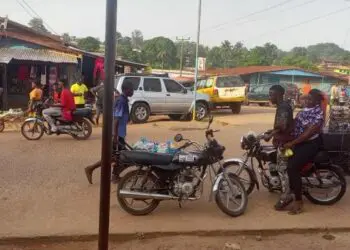 Motorcycles and riders on a busy street in Gbarnga, Bong County, where police have imposed a late-night travel ban to curb rising robberies.