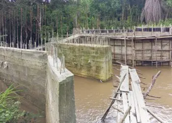 Unfinished bridge construction in Douta, Bong County, Liberia, where residents risk deadly creek crossings on a fragile wooden structure due to stalled works.