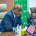 Former Finance Minister Samuel D. Tweah Jr. speaking at a meeting with the Liberian flag and EU flag on the table.