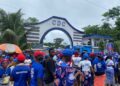 Entrance gate of the Congress for Democratic Change (CDC) headquarters in Congo Town, Monrovia, with party colors and signage clearly visible on a quiet street.