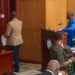 Senator McGill in brown jacket and blue jeans leaving the chamber