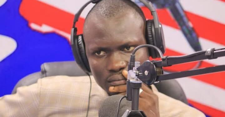 man sitting behind a microphone