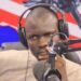 man sitting behind a microphone