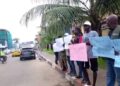people standing along the road holding placards