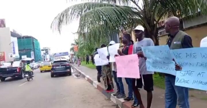 people standing along the road holding placards