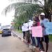 people standing along the road holding placards