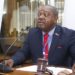 LNBA president speaks into a microphone with a gavel on his desk