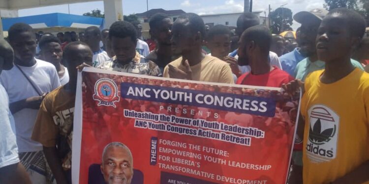 Young members of the ANC Youth Congress hold a banner during a youth leadership retreat in Monrovia, Liberia, promoting the theme “Empowering Youth Leadership for Liberia’s Transformative Development,” with a photo of ANC political leader Alexander B. Cummings