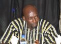striped traditional African shirt sits at a table