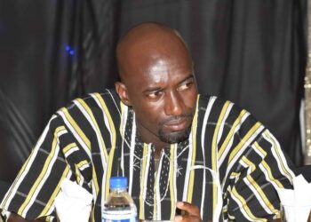 striped traditional African shirt sits at a table