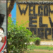 Split image showing (left) a young Liberian mother, Jamesetta Kugmeh, lying in a hospital bed with an oxygen mask and holding her newborn baby after undergoing emergency treatment at ELWA Hospital; and (right) the front entrance sign of ELWA Hospital in Monrovia, Liberia, reading “WELCOME TO ELWA HOSPITAL