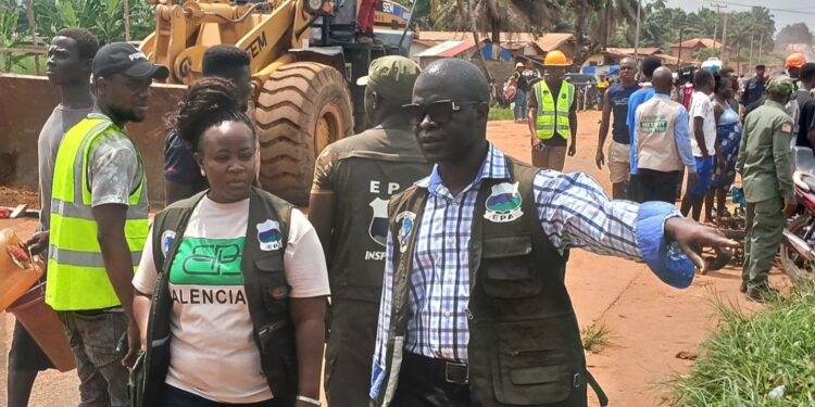 EPA Executive Director Emmanuel Yarkpawolo leads demolition operation against illegal wetland construction in Johnsonville