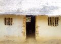 Cracked mud-walled Gbi-Doru Courthouse with thatched roof, lacking basic infrastructure