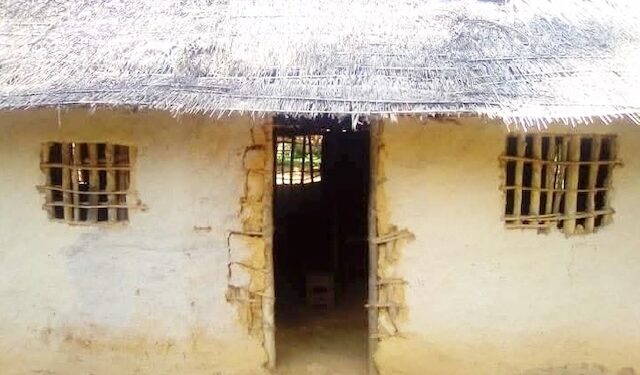 Cracked mud-walled Gbi-Doru Courthouse with thatched roof, lacking basic infrastructure