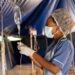 Liberian nurse adjusts IV drip inside a makeshift hospital tent,