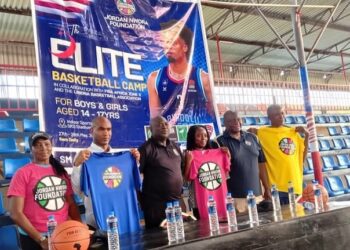 Officials from the Jordan Nwora Foundation and Liberia Basketball Association pose with branded shirts at the launch of the 2025 youth basketball camp in Monrovia.