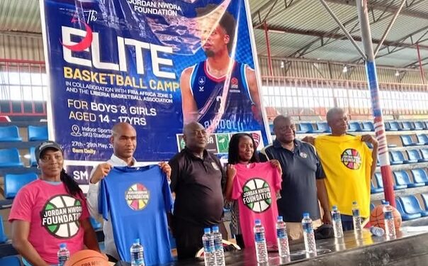 Officials from the Jordan Nwora Foundation and Liberia Basketball Association pose with branded shirts at the launch of the 2025 youth basketball camp in Monrovia.