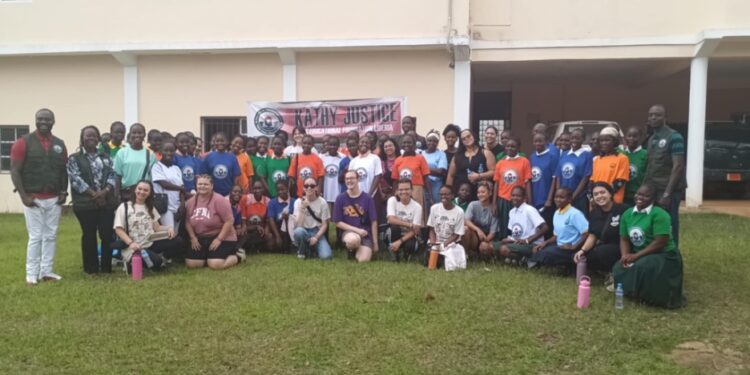Group photo of 47 Gbarnga schoolgirls, American youth missionaries, and organizers during a workshop by Kathy Justice Girls Educational Liberia on teen pregnancy and drug abuse prevention.