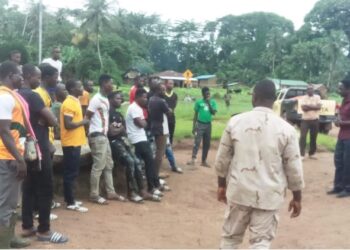 Liberia Immigration Service officers conducting a registration session with Burkinabé nationals in a rural area during the national migrant documentation campaign.