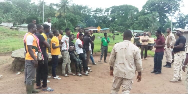 Liberia Immigration Service officers conducting a registration session with Burkinabé nationals in a rural area during the national migrant documentation campaign.