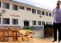 Moussa Abdul Karim, Lebanese businessman, in front of the University of Liberia’s fisheries department, with images of timber he allegedly smuggled.