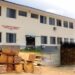 Moussa Abdul Karim, Lebanese businessman, in front of the University of Liberia’s fisheries department, with images of timber he allegedly smuggled.
