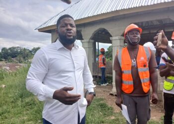 Rep. Moima Briggs Mensah’s Chief of Office Staff, Murfee Anderson, defends a legislative development project in Salala, Bong County, during a site visit with contractors and staff.