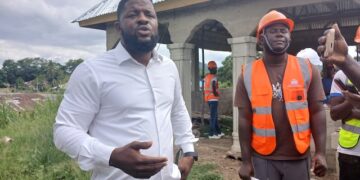 Rep. Moima Briggs Mensah’s Chief of Office Staff, Murfee Anderson, defends a legislative development project in Salala, Bong County, during a site visit with contractors and staff.