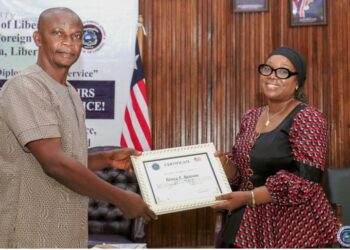 Foreign Minister Sara Beysolow Nyanti presents a certificate of appreciation to a retiree during a ceremony at the Ministry of Foreign Affairs in Monrovia, Liberia