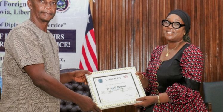 Foreign Minister Sara Beysolow Nyanti presents a certificate of appreciation to a retiree during a ceremony at the Ministry of Foreign Affairs in Monrovia, Liberia