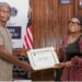 Foreign Minister Sara Beysolow Nyanti presents a certificate of appreciation to a retiree during a ceremony at the Ministry of Foreign Affairs in Monrovia, Liberia
