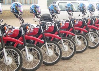 Lineup of red Yamaha motorbikes with helmets donated by Plan International Liberia to Maryland County health authorities to support rural healthcare delivery