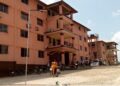 Front view of Prince Y. Johnson Polyethnic University in Ganta, Liberia, with students and motorcycles gathered outside during closure