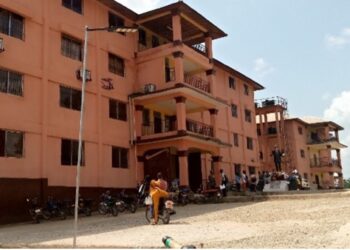 Front view of Prince Y. Johnson Polyethnic University in Ganta, Liberia, with students and motorcycles gathered outside during closure