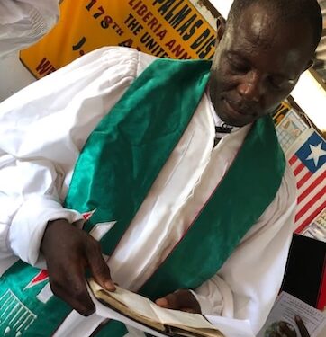 Rev. Lemeo G. Ivy, the 49-year-old pastor charged with negligent homicide, reads from the Bible before his arrest in Harper, Maryland County.