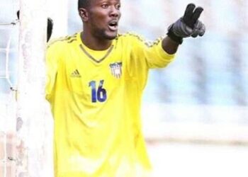 Liberian goalkeeper Tommy Sango in action during a national match, wearing jersey number 16 and pointing from his goalpost.
