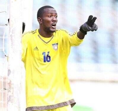 Liberian goalkeeper Tommy Sango in action during a national match, wearing jersey number 16 and pointing from his goalpost.