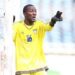 Liberian goalkeeper Tommy Sango in action during a national match, wearing jersey number 16 and pointing from his goalpost.