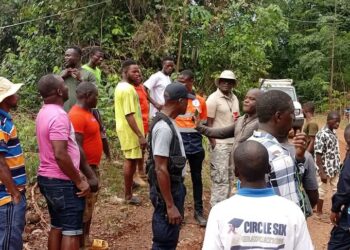 Local residents, mining company workers, and officials gather in Gbakonai, Bong County, during a government-led community engagement to address a mining license dispute between H&K Mining and Da-Tahn Company.