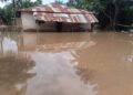 A flooded house in Gbarnga, Bong County, Liberia, surrounded by brown floodwaters with no clear drainage route