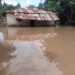 A flooded house in Gbarnga, Bong County, Liberia, surrounded by brown floodwaters with no clear drainage route