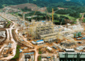 Aerial view of ArcelorMittal Liberia’s newly completed iron ore concentrator in Yekepa, Nimba County, showing heavy machinery, construction structures, and surrounding forested landscape.