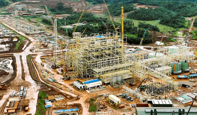 Aerial view of ArcelorMittal Liberia’s newly completed iron ore concentrator in Yekepa, Nimba County, showing heavy machinery, construction structures, and surrounding forested landscape.
