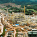 Aerial view of ArcelorMittal Liberia’s newly completed iron ore concentrator in Yekepa, Nimba County, showing heavy machinery, construction structures, and surrounding forested landscape.