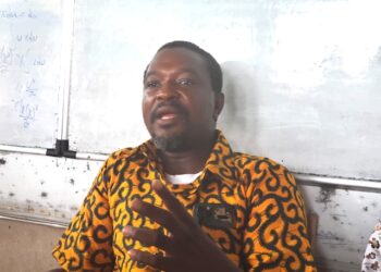 Armstrong Gobac Selekpoh addresses journalists in front of a whiteboard, speaking on behalf of Nimba host communities in defense of the ArcelorMittal Liberia concession deal.