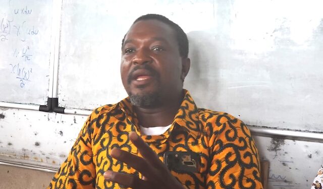 Armstrong Gobac Selekpoh addresses journalists in front of a whiteboard, speaking on behalf of Nimba host communities in defense of the ArcelorMittal Liberia concession deal.